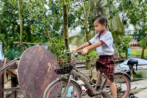 Nguyễn Đại Phong trên chiếc xe đạp đi học hằng ngày của em. Ảnh: Thùy Linh.