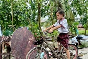 Nguyễn Đại Phong trên chiếc xe đạp đi học hằng ngày của em. Ảnh: Thùy Linh.