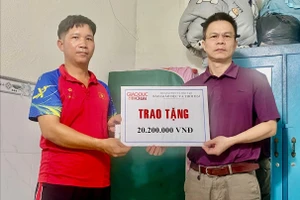 Ông Trần Mạnh Thường (phải) trao tiền ủng hộ cho cha bé gái. Ảnh: Thường Quân.