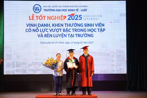 PGS.TS Hoàng Công Gia Khánh, Hiệu trưởng Trường Đại học Kinh tế - Luật trao bằng cử nhân và khen thưởng của trường cho Hoàng Chi Mạnh (giữa). Ảnh: P.L