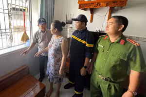 Ông Mai Quang, Phó Chủ tịch UBND phường Bình Quới (trái) cùng lực lượng chức năng vận động người dân chung cư Thanh Đa tháo dỡ "chuồng cọp". (Ảnh: Hà An)