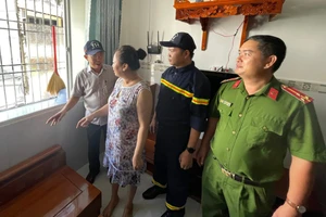 Ông Mai Quang, Phó Chủ tịch UBND phường Bình Quới (trái) cùng lực lượng chức năng vận động người dân chung cư Thanh Đa tháo dỡ "chuồng cọp". (Ảnh: Hà An)