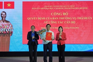 Ông Phạm Tiến Đạt (giữa) nhận quyết định của Ban Thường vụ Thành ủy TPHCM. Ảnh: K.H