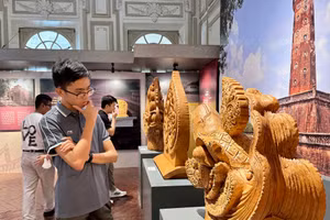 Du khách xem cổ vật tượng đầu chim phượng bằng chất liệu đất nung, có niên đại thời nhà Lý (1009-1225). Ảnh: Thùy Linh