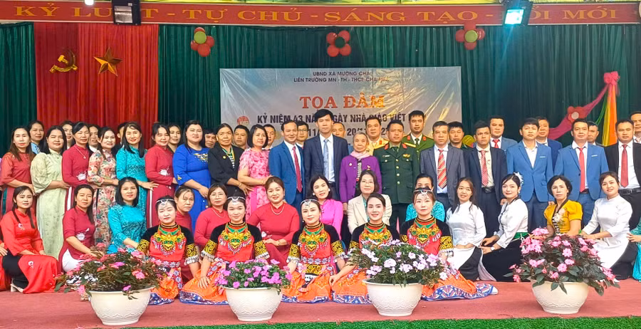 Ông Nguyễn Hữu Đại - Chủ tịch UBND xã Mường Chà (áo đen đứng giữa) chup ảnh cùng các đại biểu dự kỷ niệm Ngày Nhà giáo Việt Nam cùng giáo viên Liên trường Mầm non, Tiểu học, THCS Chà Nưa.