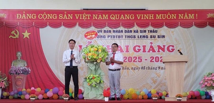 Ông Đặng Thành Huy - Bí thư Đảng ủy xã Sín Thầu (bên trái) tặng hoa chúc mừng thầy trò Trường PTDTBT THCS Leng Su Sìn nhân dịp khai giảng năm học mới. sin-thau-noi-tru-2.jpg