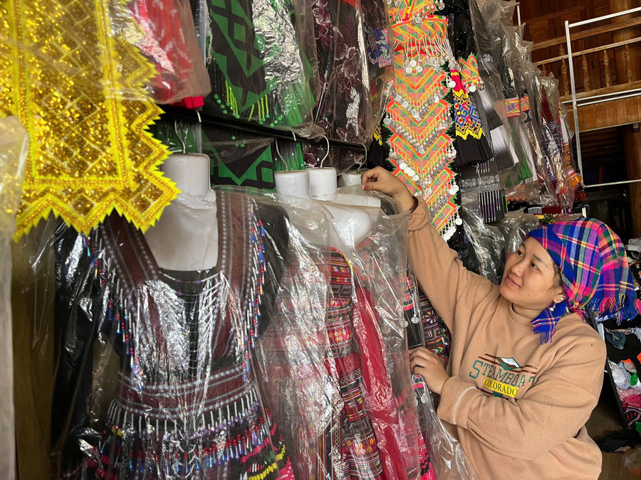 Chị Giàng Thị Lan sắp xếp lại các bộ trang phục dân tộc đón khách mua hàng.