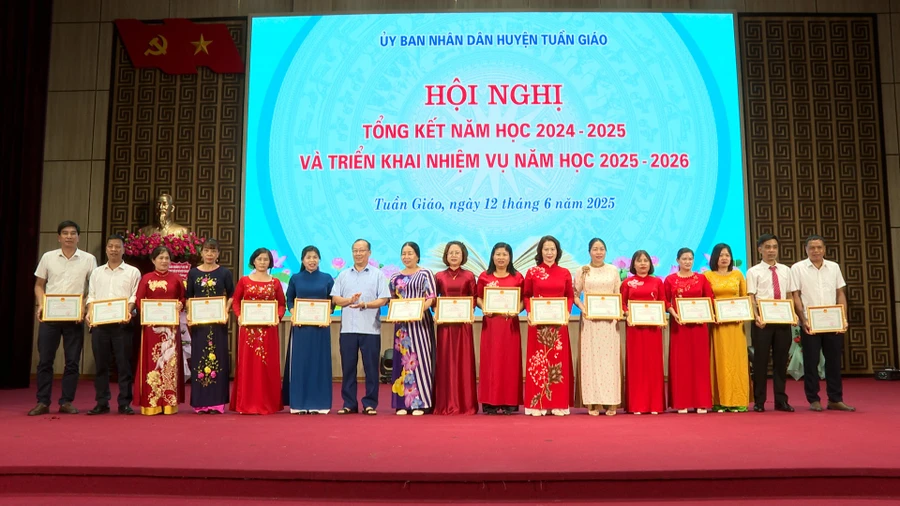 Ông Mùa Va Hồ (thứ 7 từ bên trái) trao giấy khen của UBND huyện Tuần Giáo cho các tập thể có thành tích xuất sắc (Ảnh: Lường Phượng).