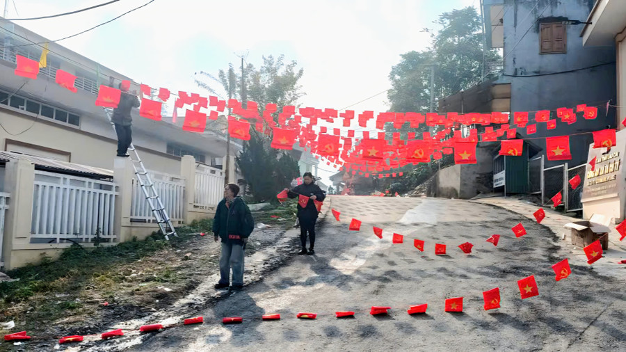 Cán bộ xã Tả Củ Tỷ treo cờ dọc con đường tại trung tâm xã.