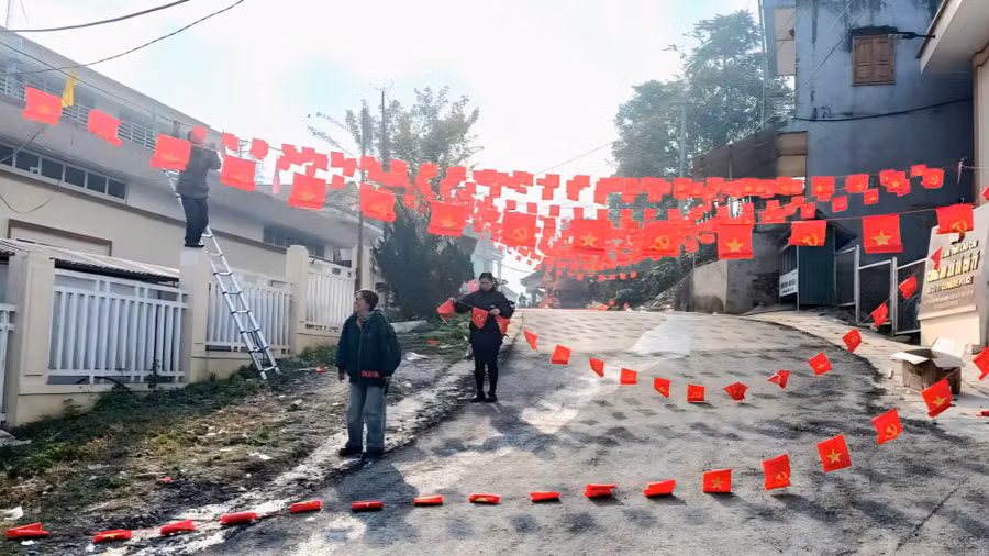 Cán bộ xã Tả Củ Tỷ treo cờ dọc con đường tại trung tâm xã.