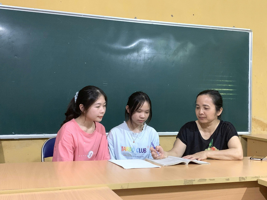Cô Vũ Thị Kim Tuyến (ngoài cùng bên phải) trao đổi bài với học sinh. (Ảnh: Trường PTDTNT THPT tỉnh Điện Biên)