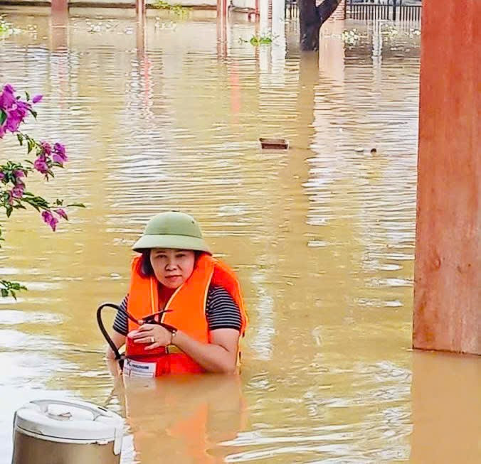 Bà Vũ Thu Hương dầm mình trong nước lũ để sơ tán đồ đạc của nhà trường. trung-thu-2.jpg