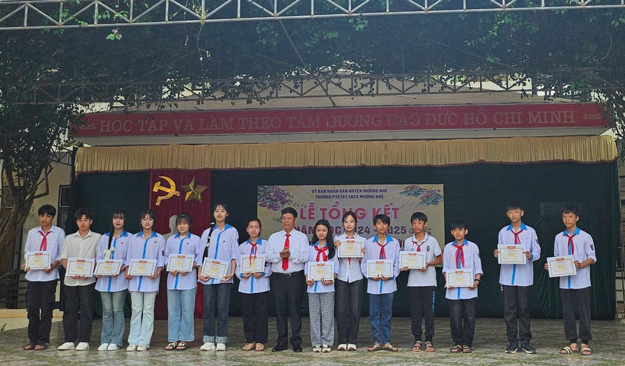 Ông Dương Tiến Công – Hiệu trưởng nhà trường (đứng giữa) trao giấy khen cho học sinh có thành tích xuất sắc trong học tập. thcs-muong-nhe-2-3.jpg