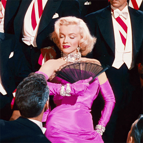 Gentlemen Prefer Blondes (1953) – Chiếc váy satin hồng đỏng đảnh Trong Gentlemen Prefer Blondes, Marilyn Monroe đã mặc chiếc váy màu hồng để trình diễn ca khúc Diamonds Are a Girl’s Best Friend. Cô mặc chiếc váy, đeo găng tay hồng với rất nhiều kim cương và hình ảnh này thật sự đã khiến cho vị trí biểu tượng thời trang của Marilyn càng được củng cố vững chắc hơn. Bộ váy này sau đó cũng đã trở thành một trong những hình ảnh đặc trưng của Marilyn, thậm chí nó đã được Madonna tái hiện trong MV ca nhạc Material Girl. Chiếc váy này cũng được thiết kế bởi William Travilla.