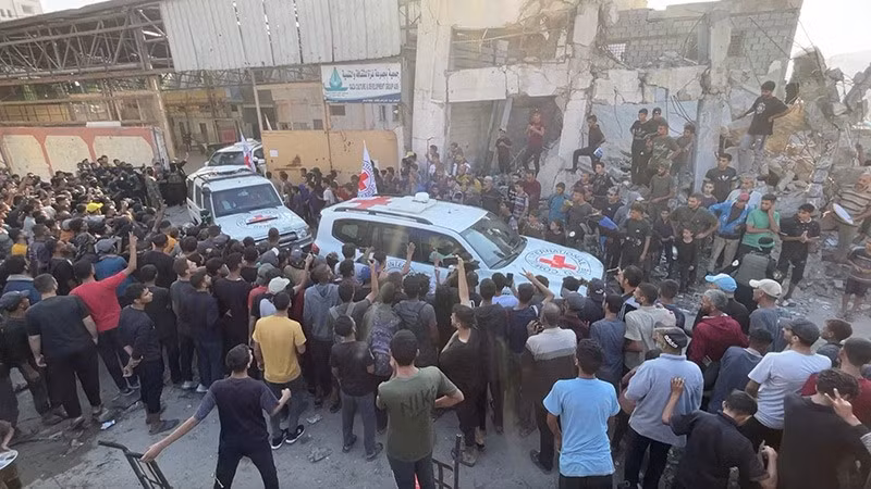 Xe của Hội Chữ thập đỏ vận chuyển các con tin sau khi được bàn giao theo thỏa thuận ngừng bắn và trao đổi con tin – tù nhân giữa Hamas và Israel, tại Gaza City, ngày 13/10. Ảnh: Reuters chum-anh-cac-con-tin-tro-ve-israel-011.jpg