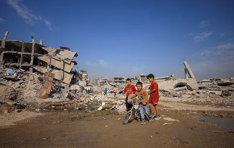 Những cậu bé Palestine đi ngang qua đống đổ nát của các tòa nhà bị phá hủy, giữa lệnh ngừng bắn giữa Israel và Hamas, tại Gaza City. chum-anh-dai-gaza-khi-mua-dong-dang-den-gan-1105-014.jpg