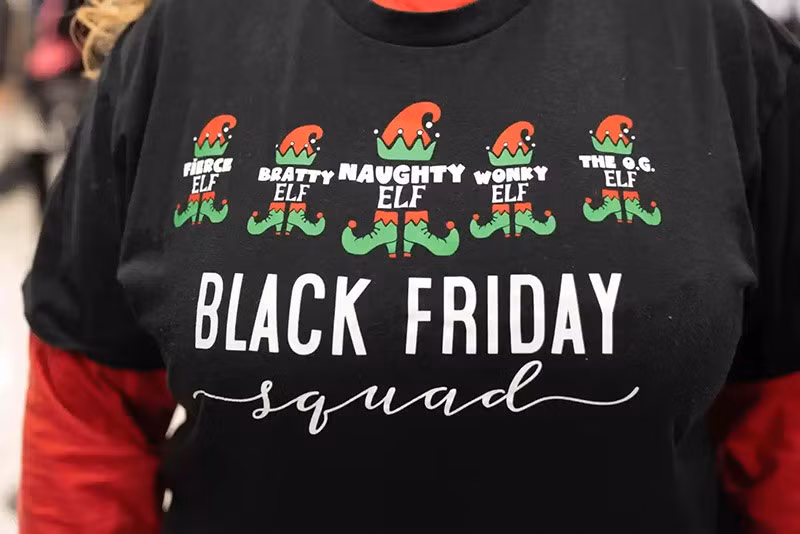 Chiếc áo của một phụ nữ trong nhóm 5 người mặc áo giống nhau cùng đi mua sắm Black Friday khi khách hàng tham quan cửa hàng Kohl’s ở Woodstock, bang Georgia. Ảnh: AP chum-anh-ngay-mua-sam-lon-nhat-nam-black-friday-1105-014.jpg