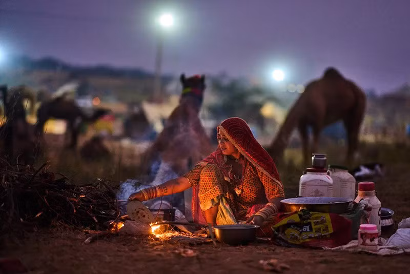 Một phụ nữ chuẩn bị thức ăn tại hội chợ thường niên ở Pushkar, bang Rajasthan, Ấn Độ. Ảnh: AP. chum-anh-hoi-cho-lac-da-o-pushkar-an-do-1105-014.jpg