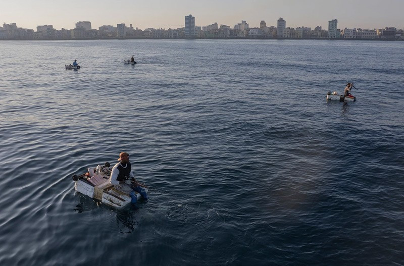 Nhìn từ xa, những tấm bè trông giống như những chấm trắng nhỏ trôi nổi trên biển. Gần hơn, bạn sẽ thấy mọi người ngồi trên những hình chữ nhật bằng xốp. chum-anh-nguoi-dan-cuba-su-dung-be-corchos-bat-ca-01.jpg