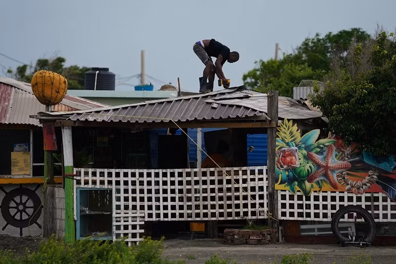 Một người đàn ông gia cố mái nhà trước khi Bão Melissa dự kiến đổ bộ vào Kingston, Jamaica. chum-anh-bao-melissa-anh-huong-vung-caribe-05-07.jpg
