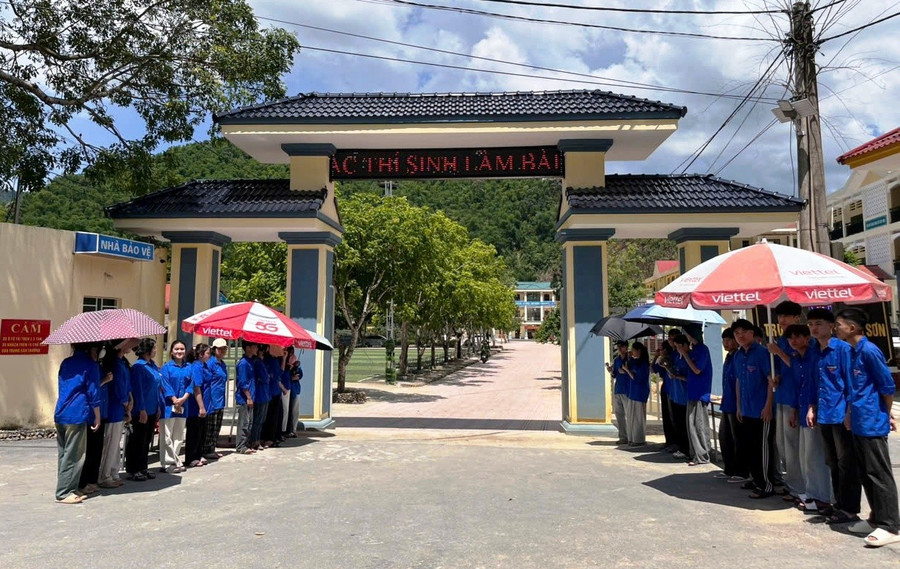 Lực lượng Thanh niên tình nguyện đội nắng ở cổng Trường THPT Quan Sơn (Thanh Hóa) hỗ trợ thí sinh đến làm thủ tục dự thi. 1eb9a925-22b2-4c18-bdf2-64e95f14f6b0.jpg