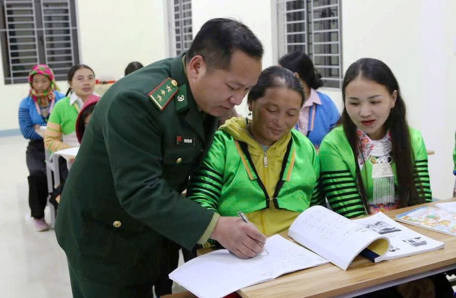 Đại úy Thao Văn Chứ nắn nót dạy từng chữ cho học viên. Ảnh: Đồn Biên phòng Quang Chiểu.