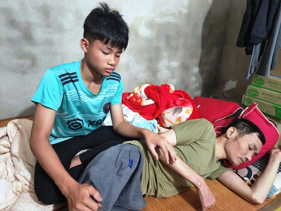 Nguyễn Xuân Nam chăm sóc người cha liệt giường.
