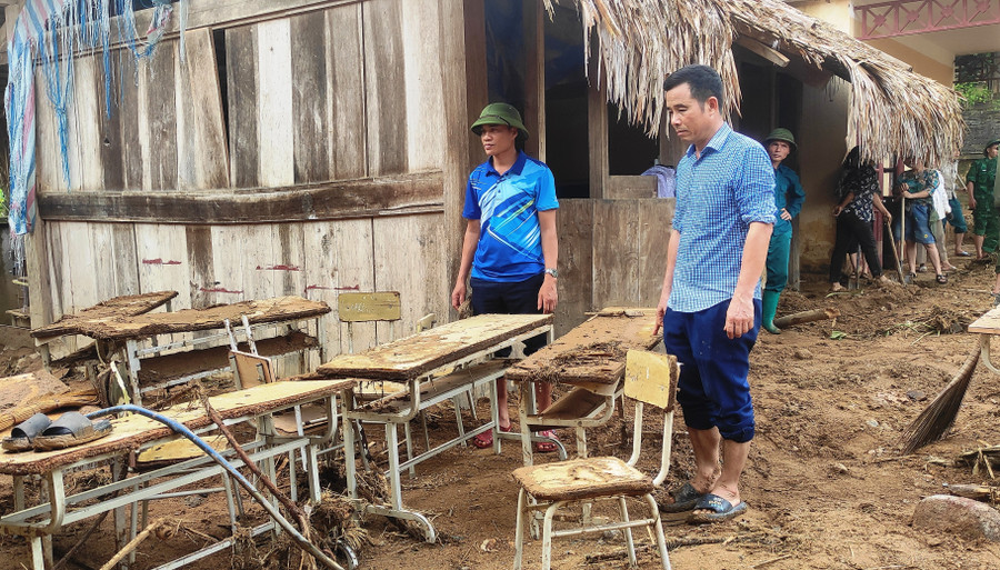 Ông Đỗ Xuân Sơn - Hiệu trưởng Trường Tiểu học Tam Thanh bần thần trước những bộ bàn ghế của điểm trương bị lũ tàn phá. 1.jpg