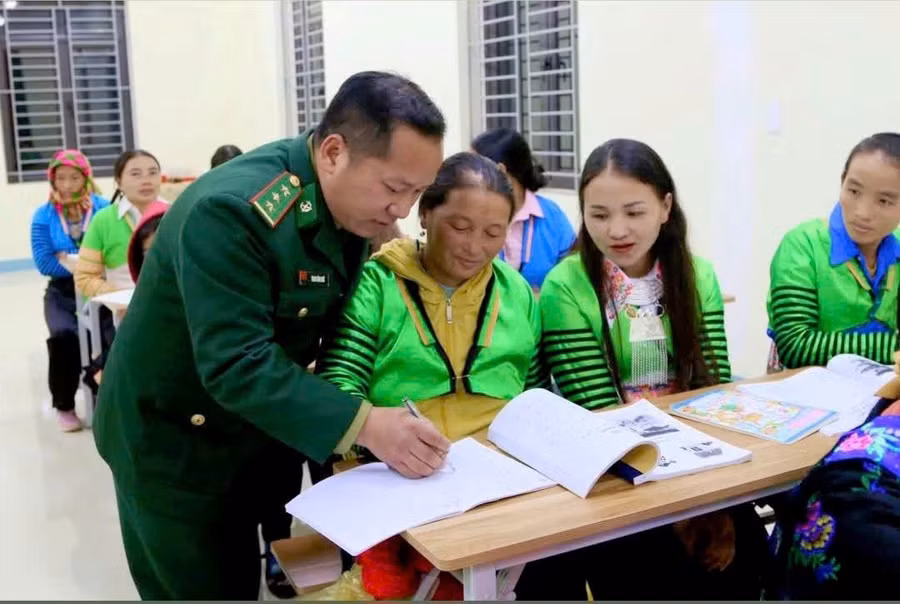 Cán bộ Đồn Biên phòng Quang Chiểu dạy chữ cho phụ nữ ở bản Pù Đứa. Ảnh: Thao Văn Chứ