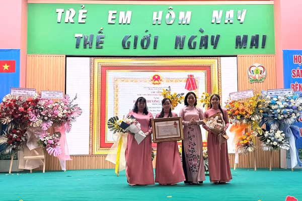 Bà Trương Thị Bích Hạnh, Phó Chủ tịch Thường trực Uỷ ban MTTQ Việt Nam TPHCM trao tặng Huân chương Lao động hạng Nhì cho Ban Giám hiệu Trường Mầm non Nhiêu Lộc. Ảnh: V.Phong