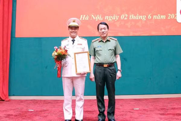 Đại tướng Lương Tam Quang, Bộ trưởng Bộ Công an trao Quyết định thăng cấp bậc hàm lên Thiếu tướng đối với Đại tá Nguyễn Ngọc Quyền (bên trái). Ảnh: Minh Đức.