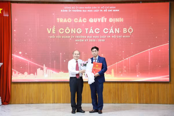Ông Trần Văn Bảy - Phó Chủ tịch UBND TPHCM trao quyết định cho TS Lê Trường Sơn - Hiệu trưởng Trường Đại học Luật TPHCM. Ảnh: ULAW. 