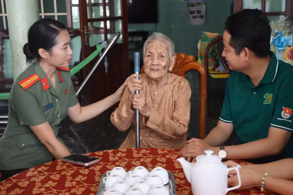 Anh Lê Tuấn Anh - Phó Bí thư Thành Đoàn TPHCM (phải) thăm và tặng quà bà mẹ Việt Nam Anh hùng Đoàn Thị Chèo. Ảnh: Lê Huy. 