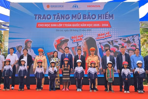 Các đại biểu trao tặng mũ bảo hiểm cho các em học sinh lớp Một trường Tiểu học Lê Quý Đôn. Ảnh: Honda.