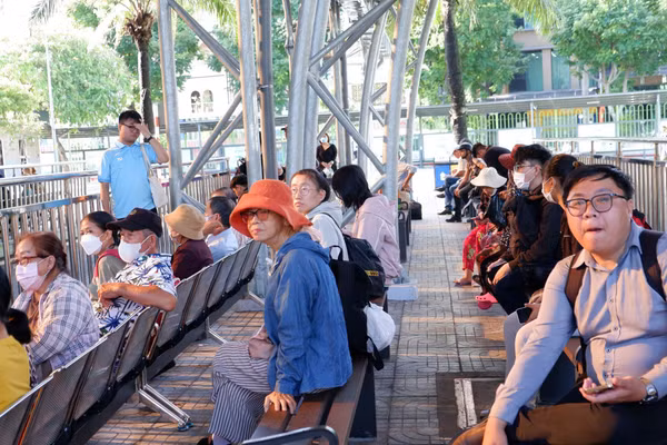 Người dân TPHCM chờ xe buýt sáng 1/7. Ảnh: Hữu Huy. 