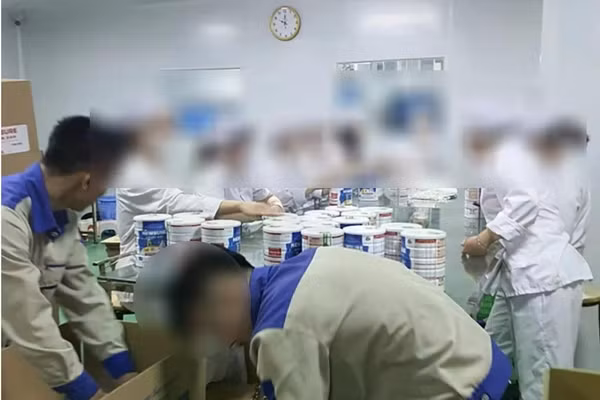 Công nhân đóng hộp thành phẩm sữa giả tại cơ sở sản xuất, chuẩn bị bán ra thị trường. Ảnh: CAND
