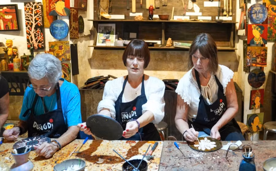 Du khách trải nghiệm làm sản phẩm sơn mài thủ công tại làng Hạ Thái. Ảnh: ITN.