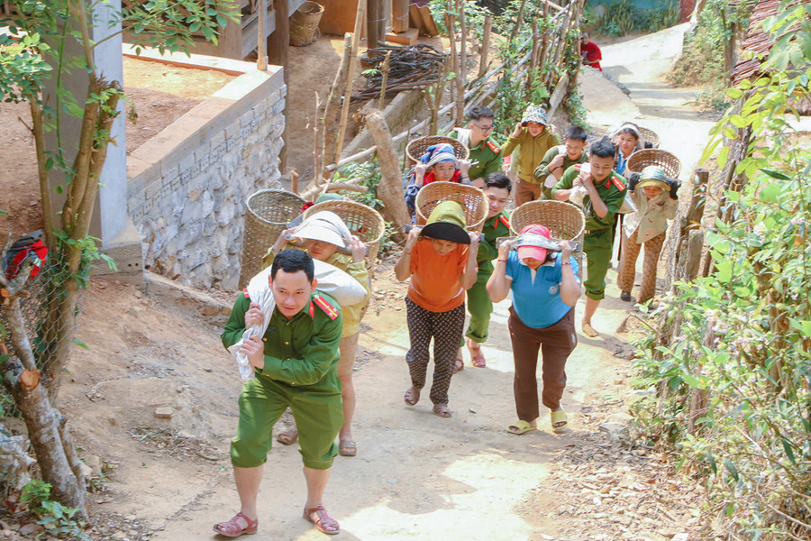 Công an xã Lượng Minh cùng người dân gùi vật liệu làm nhà. nghe-an-chung-suc-dung-nha-cho-nguoi-ngheo-2.jpg