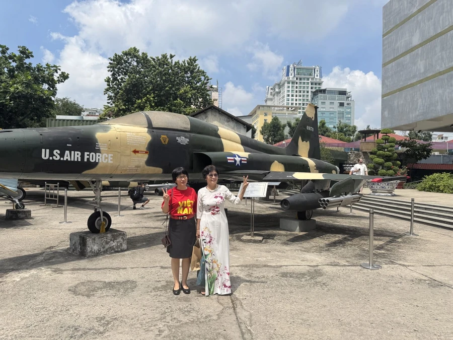 Du khách chụp hình lưu niệm trong khuôn viên Bảo tàng Chứng tích chiến tranh.