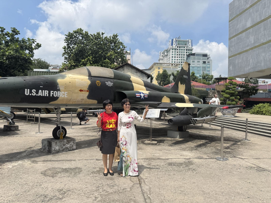 Du khách chụp hình lưu niệm trong khuôn viên Bảo tàng Chứng tích chiến tranh.