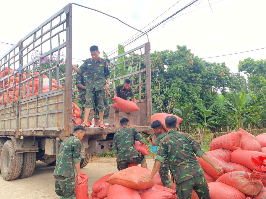 Lực lượng chức năng hỗ trợ đưa lúa của người dân đi sấy. Ảnh: P.T ha-tinh-nong-dan-mat-mua-ngay-trong-nha-3.jpg
