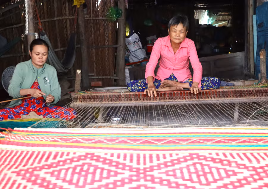 Bà Lê Thị Nhất và con gái đang dệt chiếu. 