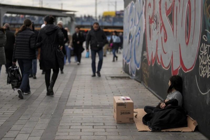 Trẻ em gái bán khăn giấy trên phố đi bộ ven biển Karakoy ở Istanbul. Ảnh: AP News