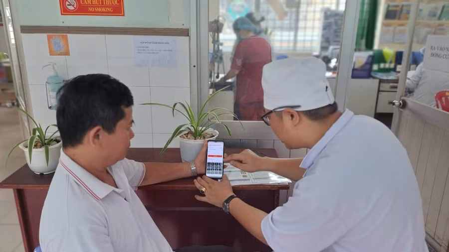 Bệnh viện Nguyễn Trãi hướng dẫn người bệnh thao tác trực tiếp trên thiết bị điện tử của người bệnh, tích hợp Sổ sức khỏe điện tử với phần mềm VNeID. Ảnh: A.T