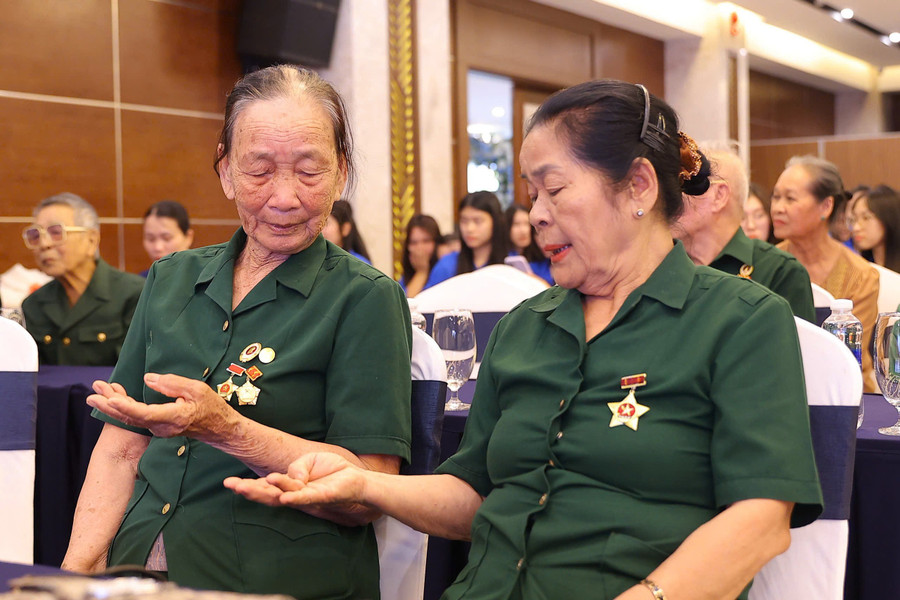Bà Nhị (bên trái) ôn lại chuyện cũ cùng đồng đội tại buổi gặp mặt cựu TNXP tỉnh Hà Tĩnh (tháng 7/2025). gap-lai-nguyen-mau-gui-em-co-thanh-nien-xung-phong-3.jpg