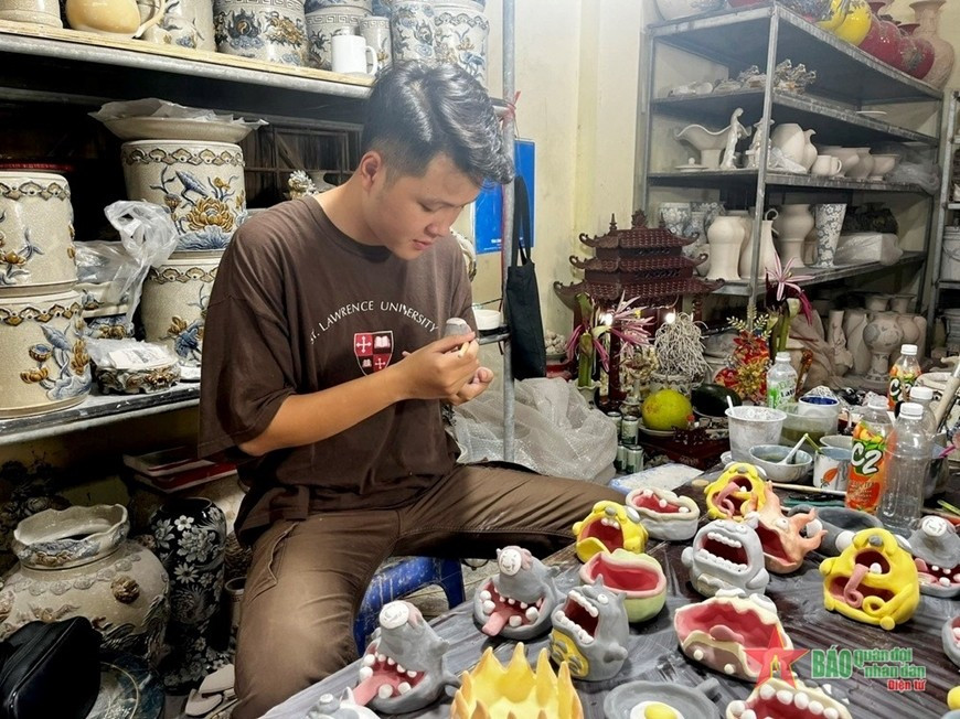Vũ Tuấn Long đang trang trí cho các sản phẩm “quái dị” của mình. Ảnh: QĐND