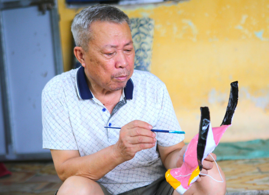 Ông Vũ Huy Đông (72 tuổi) có hơn 40 năm gắn bó với nghề làm mặt nạ giấy bồi. nhung-doi-ban-tay-giu-hon-tet-trang-ram-3.jpg