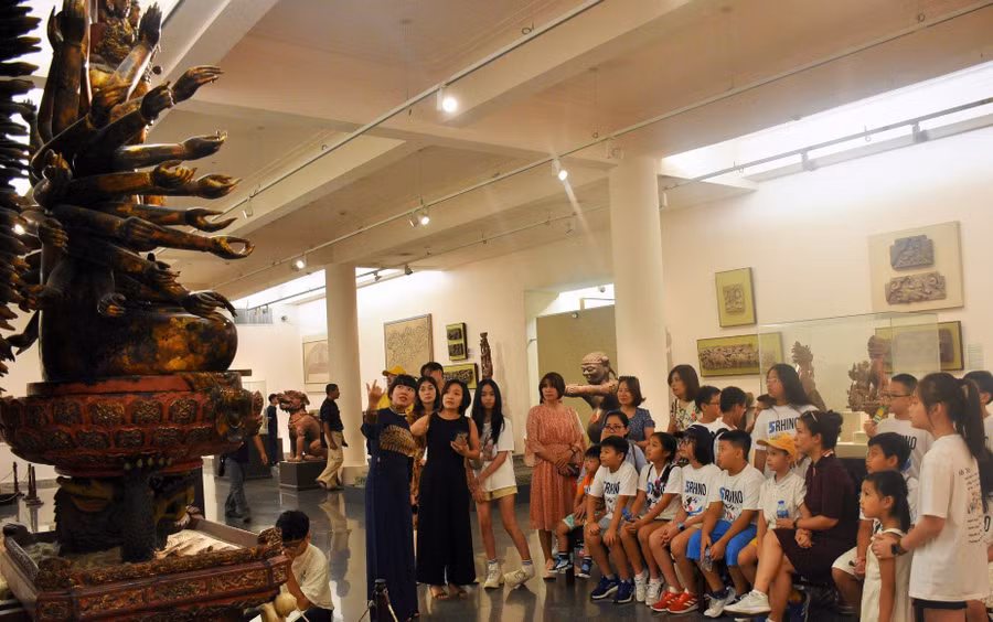 Khách tham quan bảo vật quốc gia 'Phật bà Quan Âm' tại Bảo tàng Mỹ thuật Việt Nam.