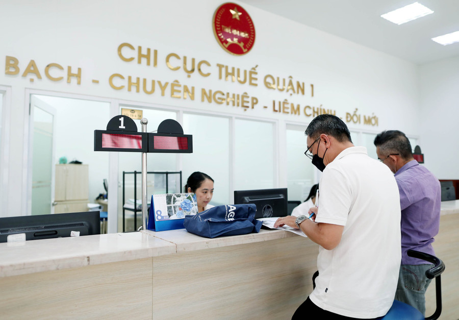 Người dân làm thủ tục tại Chi cục Thuế Quận 1 (TPHCM). Ảnh minh họa: INT bi-lay-cap-ma-so-thue-canh-bao-ve-bao-mat-thong-tin-ca-nhan.jpg
