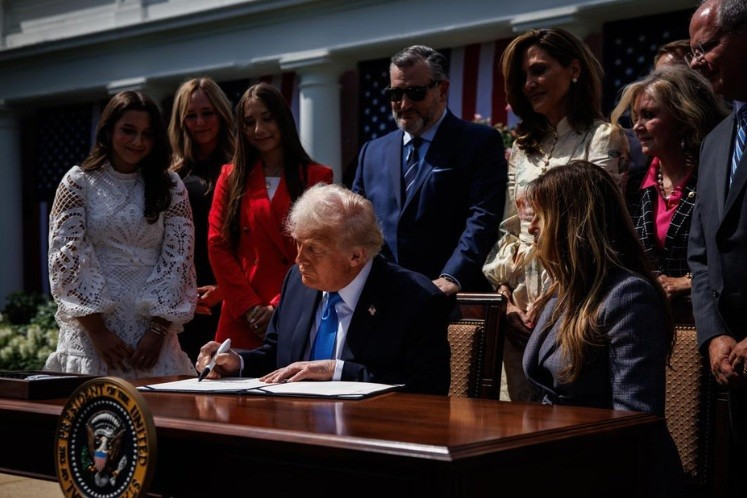 Tổng thống Donald Trump ký Đạo luật 'Take It Down', cùng với Đệ nhất phu nhân Melania Trump (phải) tại một buổi lễ ở Vườn Hồng vào ngày 19/5. Ảnh: EPA-EFE cuoc-dua-ngay-cang-khoc-liet-2.jpg